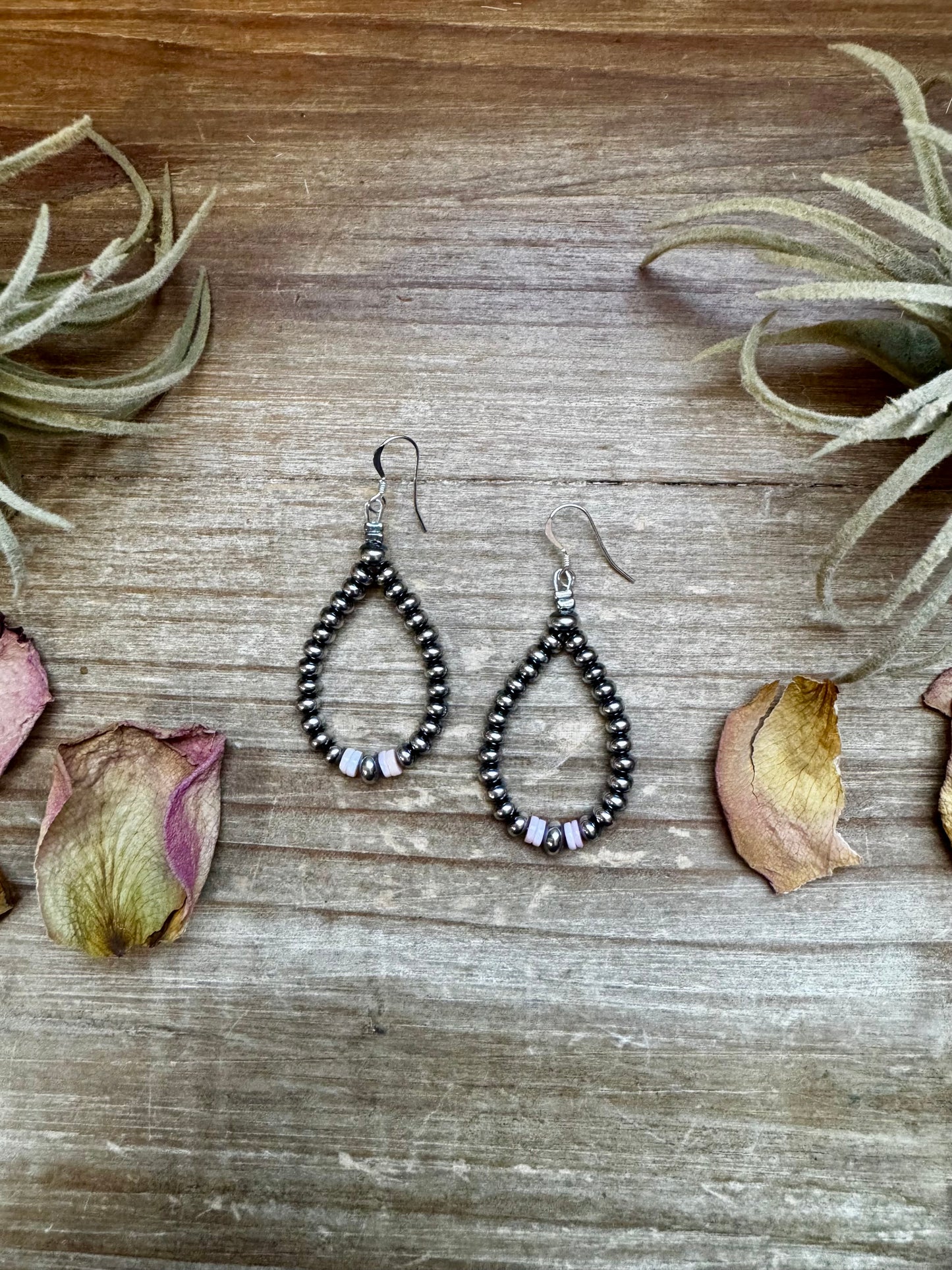 2.5-inch handmade dangle earrings featuring 4mm, 5mm, and 6mm saucer sterling silver pearls with Pink Conch Heishi accents. Includes .925 sterling silver hooks. Each pink conch shade is slightly unique. Lightweight and made in the USA by The Bijoux FAB.