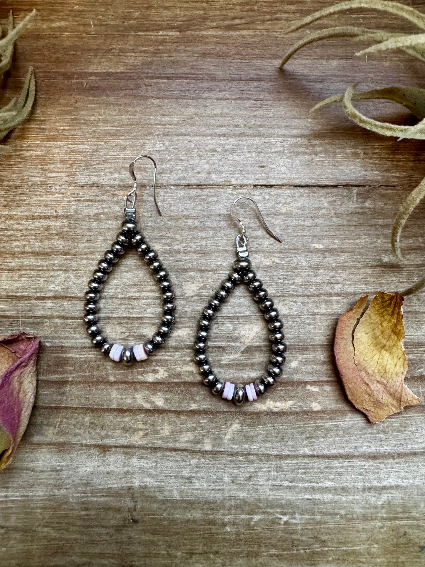 2.5-inch handmade dangle earrings featuring 4mm, 5mm, and 6mm saucer sterling silver pearls with Pink Conch Heishi accents. Includes .925 sterling silver hooks. Each pink conch shade is slightly unique. Lightweight and made in the USA by The Bijoux FAB.