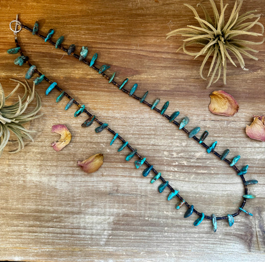 Handmade 30-inch necklace with 3mm dark shell beads and a real turquoise teardrop pendant. Silver-plated finish. Every turquoise stone is unique. Made in the USA by The Bijoux FAB. Limited quantity available.