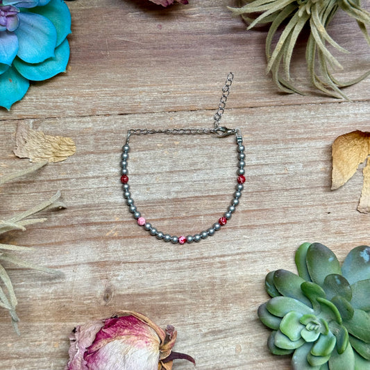 Handcrafted 6.25-inch bracelet featuring 4mm silver-plated beads and pink sea sediment round beads, finished with silver-plated findings. Made in the USA by The Bijoux FAB. Each bracelet is unique with natural variations in color and pattern.