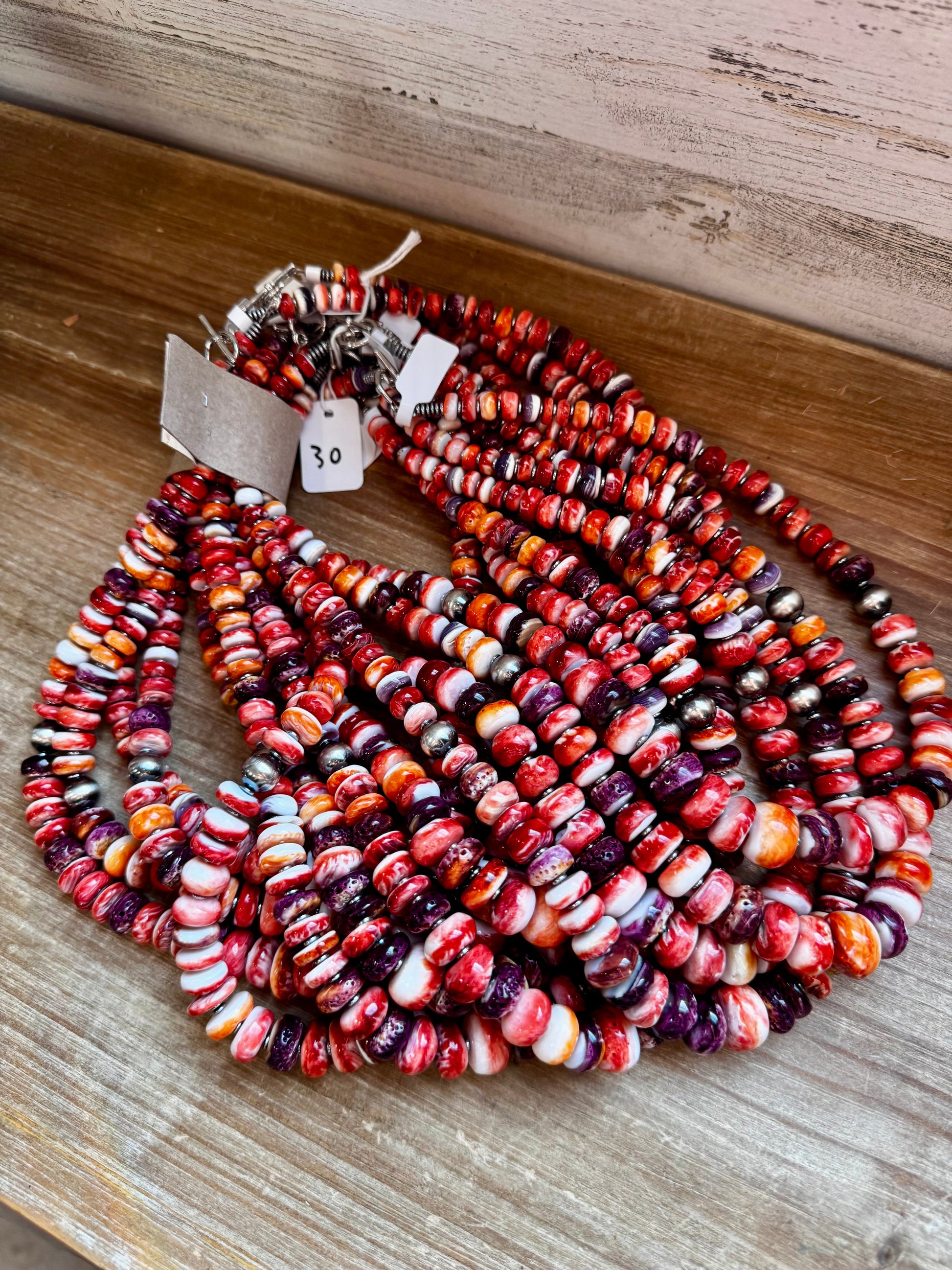 22-inch handmade necklace with vibrant spiny oyster beads in orange, red, purple, and purple wampum shell, spaced with hematite and two large sterling silver pearls