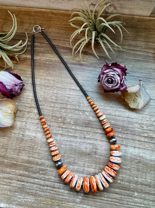 23-inch necklace with dark hematite beads, graduated orange spiny oyster, and 10mm sterling silver pearls, handmade by The Bijoux FAB in the USA