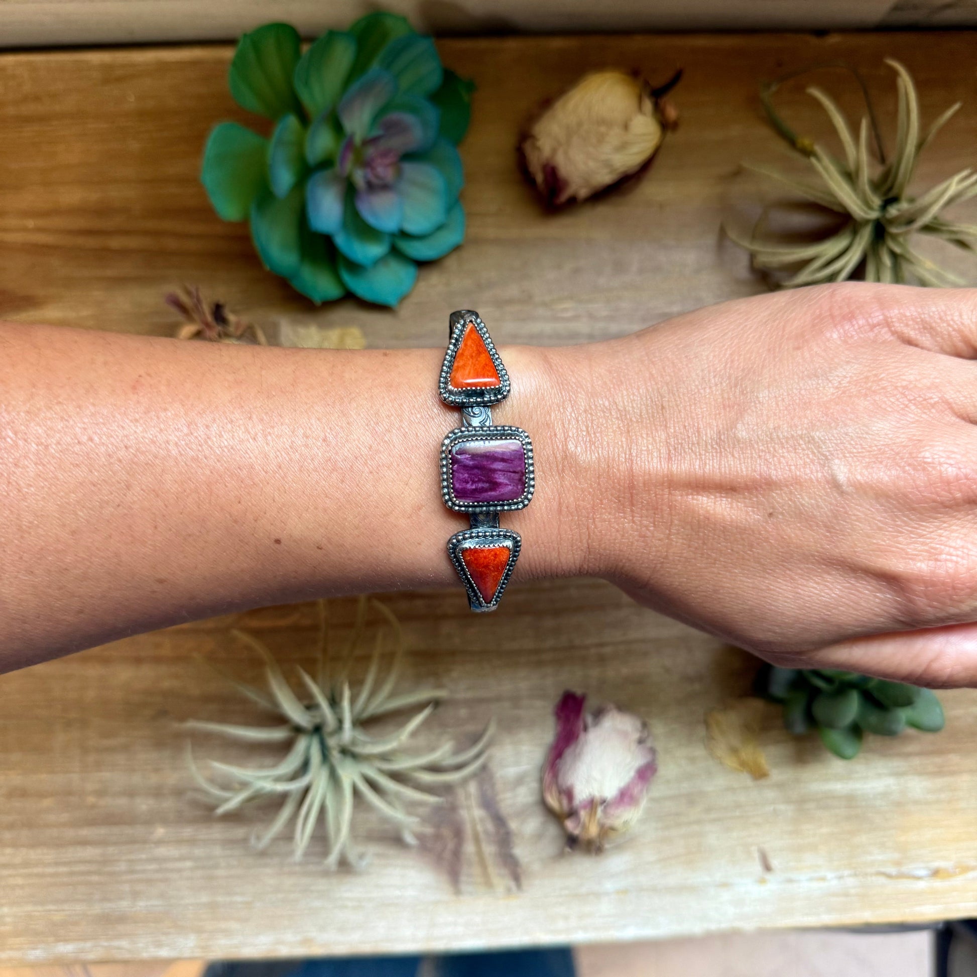 Handcrafted sterling silver cuff by MJ featuring a square purple spiny oyster stone with red spiny oyster accents.