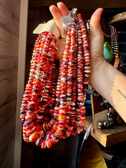 22-inch handmade necklace with vibrant spiny oyster beads in orange, red, purple, and purple wampum shell, spaced with hematite and two large sterling silver pearls