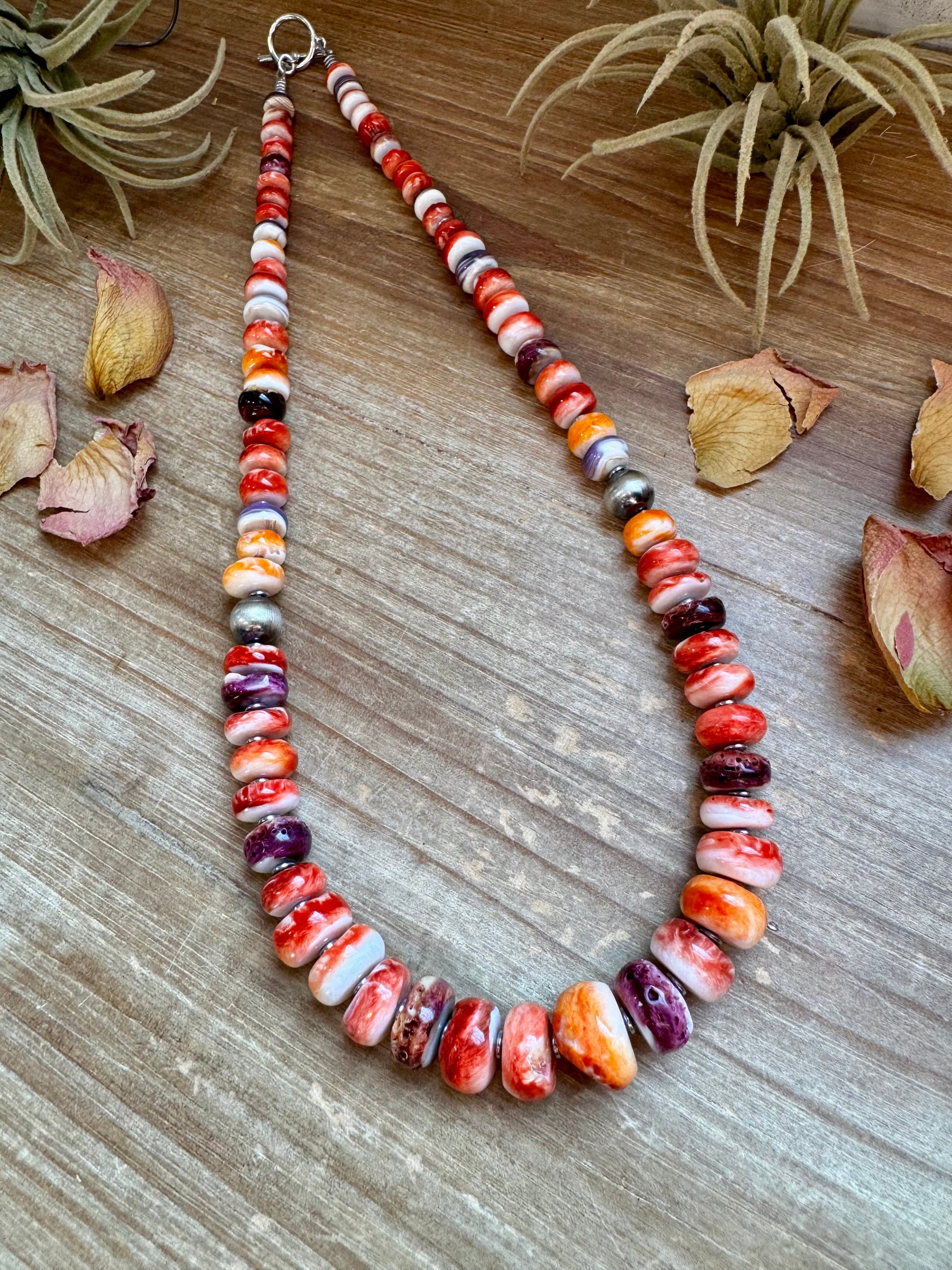 22-inch handmade necklace with vibrant spiny oyster beads in orange, red, purple, and purple wampum shell, spaced with hematite and two large sterling silver pearls