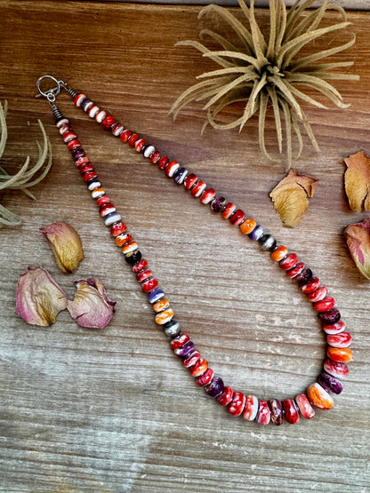 22-inch handmade necklace with vibrant spiny oyster beads in orange, red, purple, and purple wampum shell, spaced with hematite and two large sterling silver pearls