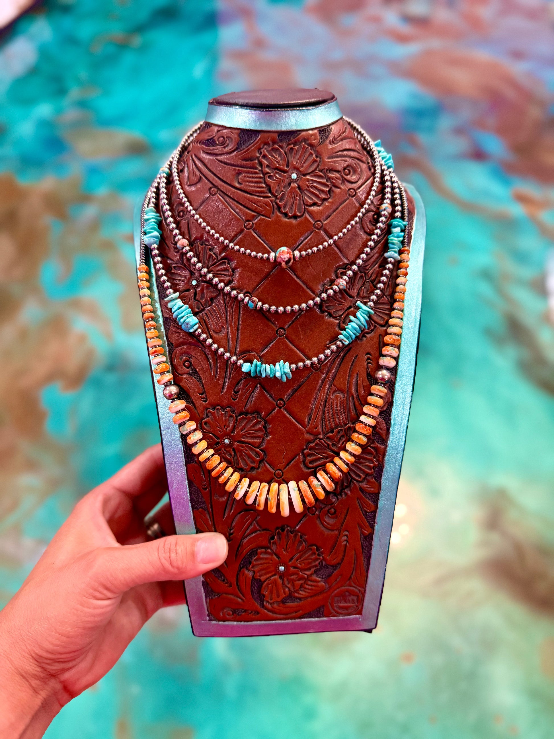Four piece colorful western necklace stack featuring Mojave turquoise, turquoise chips, orange beads, hematite, and sterling silver accents handmade by The Bijoux FAB